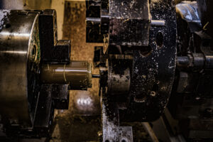 CNC Machining of PEEK | Plastic Machining Inc. Close-up of a 7-axis CNC machine in operation, shaping a piece of PEEK material.