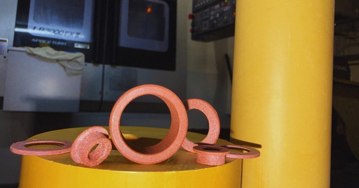 Multiple Rulon® components sit on a yellow platform in an industrial environment, next to a yellow pillar.